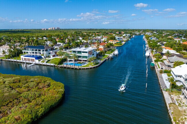 A boat navigates out of the canals in Gables By The Sea toward Biscayne Bay.