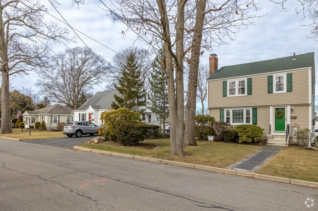 Homes in Braintree Highlands are often surrounded by lush trees.