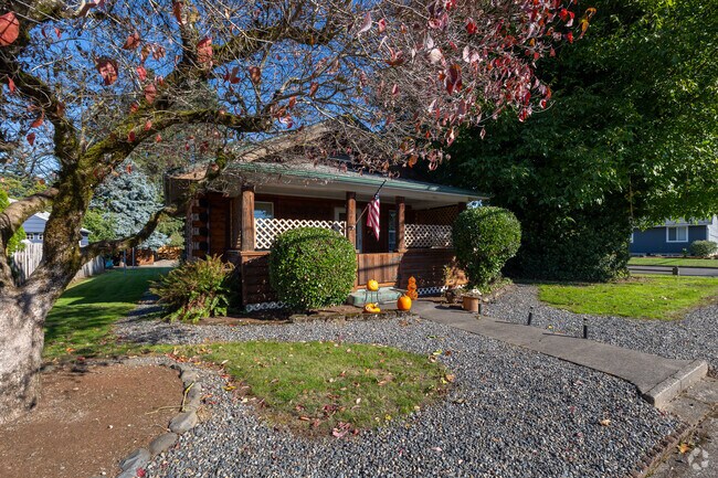 A graceful tree drapes its branches over a rustic Craftsman-style home on C Street in the heart of Downtown Washougal.