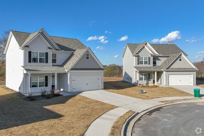 A row of charming, newly constructed homes adorned with fresh paint and modern designs line the inviting streets leading to Downtown Commerce, exuding a sense of community and vibrancy.