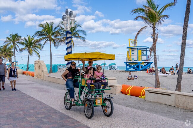 Families can all ride one of Hollywood Beach Boardwalk's popular attractions the Surrey Bike.
