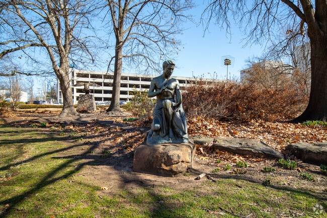 A bronze statue of a man stands on display at Swan Lake in Tulsa, Oklahoma.