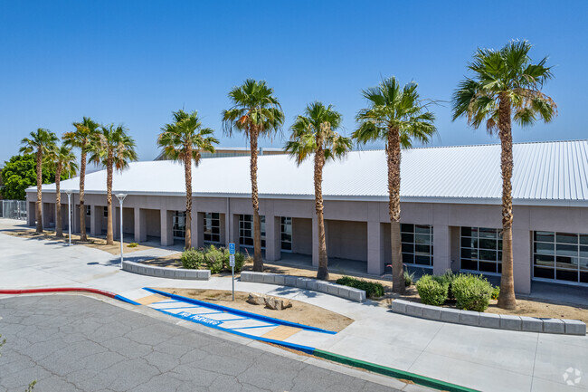 Amistad High School has palm trees lining the exterior of the building.