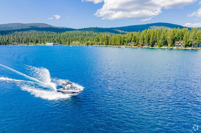A wake boat planes across the waters in front of Carnelian Bay.