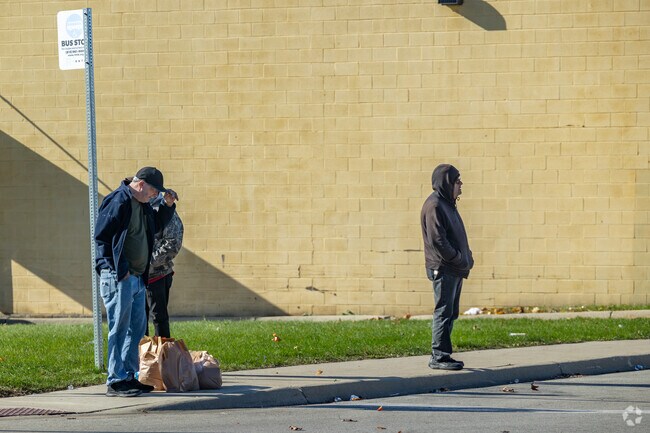 Bus riders wait at the one of many stops in the Southeast Helping Hands area.
