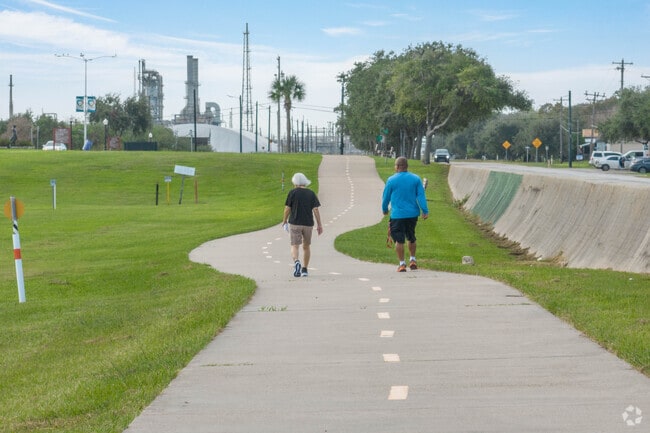 A couple enjoys a walking trail at Bay Street Park in East Texas City.