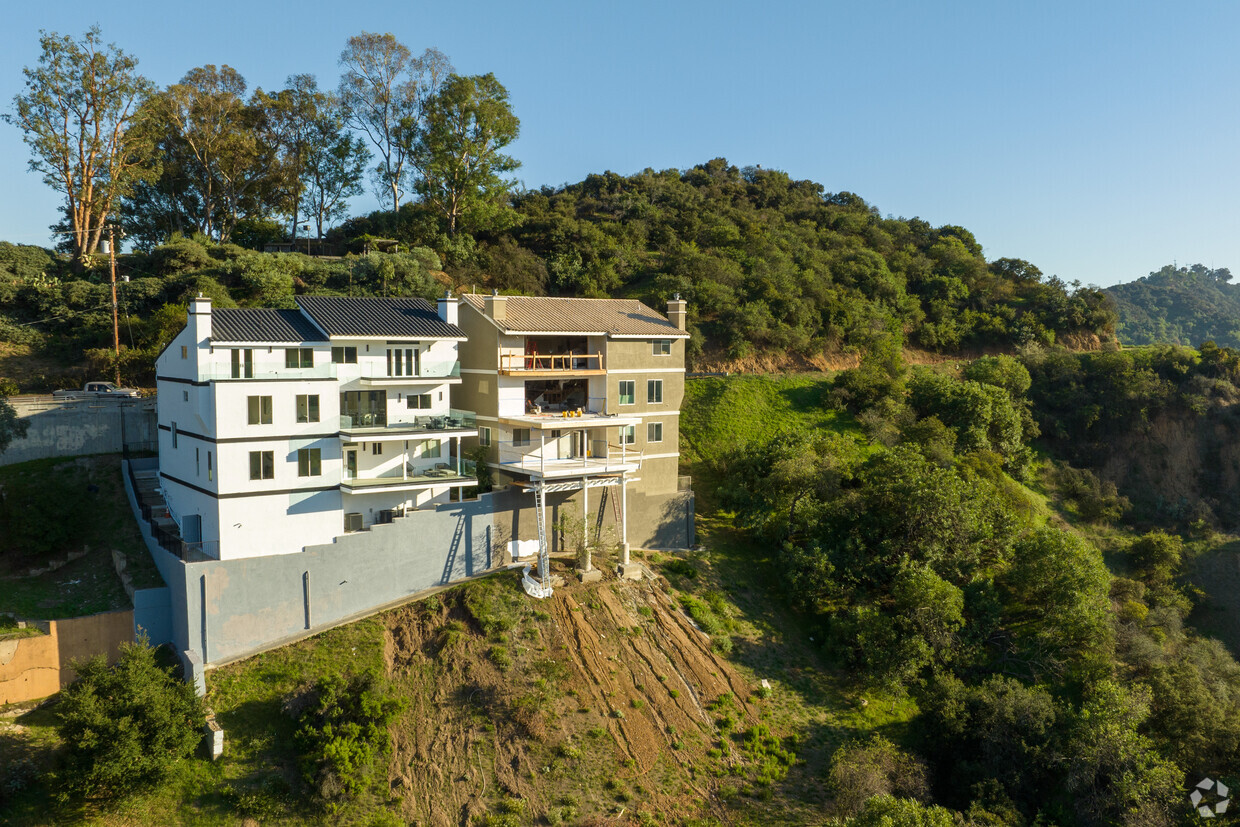 hillside house on stilts by TWO+ preserves natural surroundings