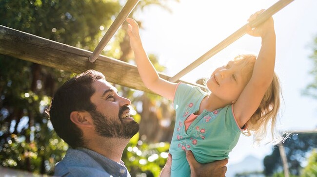 Father and daughter on the monkey bars