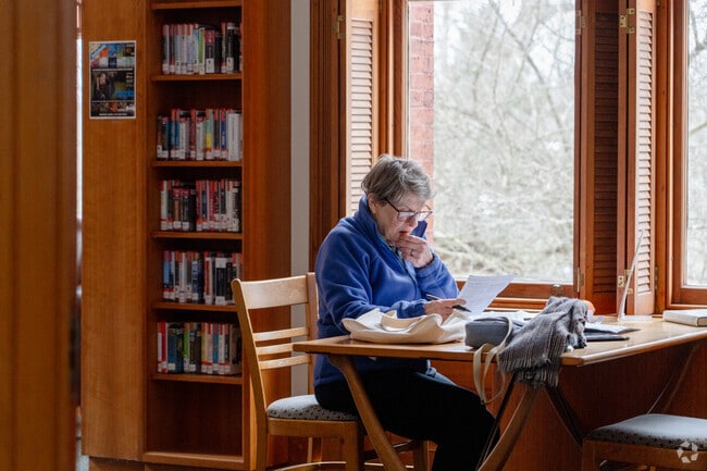 A woman reads a paper in Lincoln Public Library's wood-toned turret.