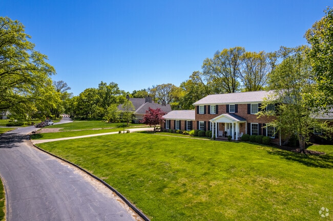 A large colonial style home sits on a large grassy lot in Frontenac.