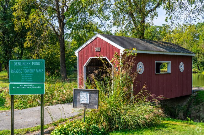 A picturesque bridge takes visitors across a stream to access Delinger Pond.