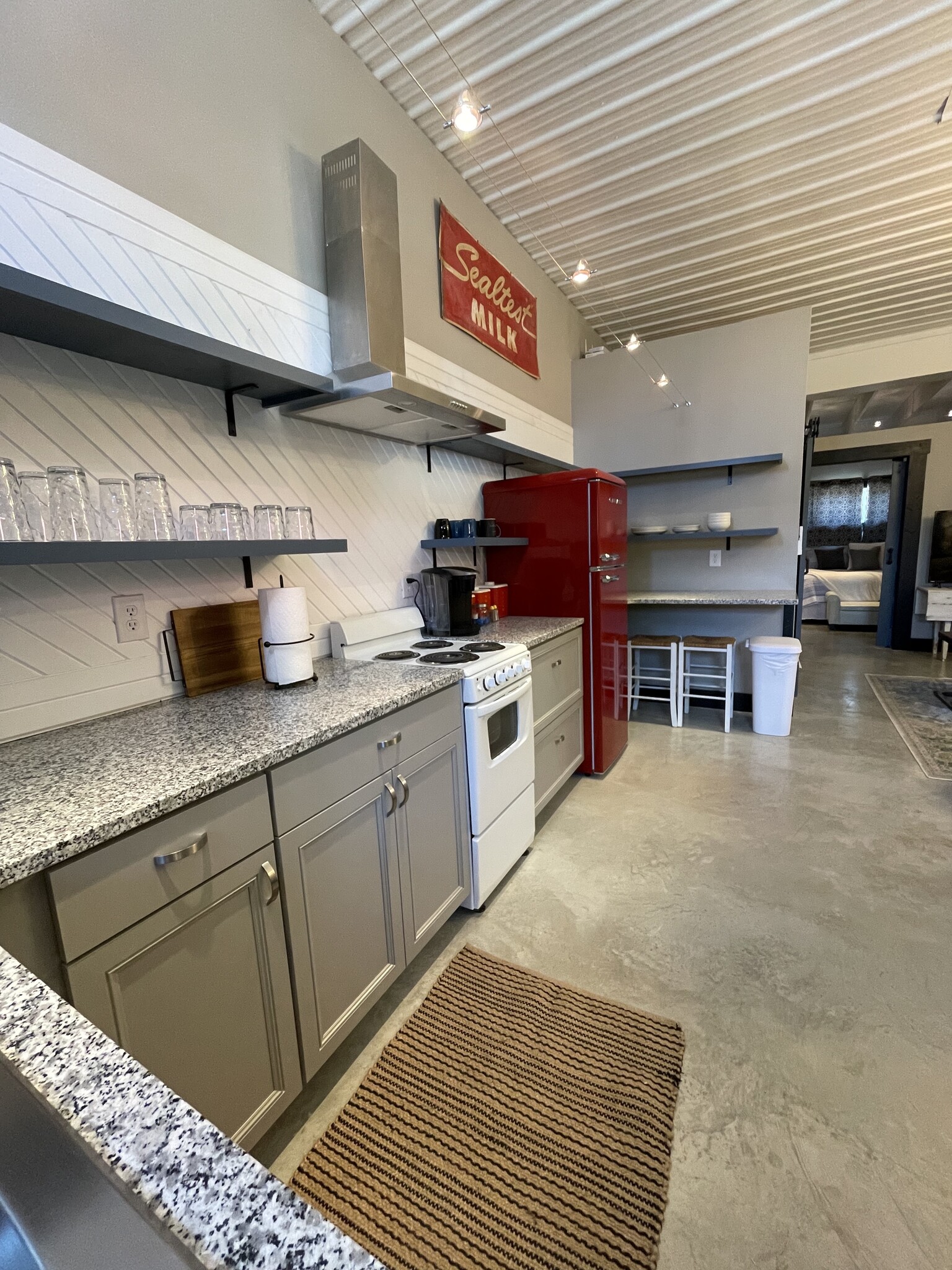 Fully furnished kitchen with range, oven, coffee maker, and refrigerator.