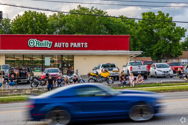 Bystanders watch cars pass on Kearney Street near the Doling Park neighborhood.