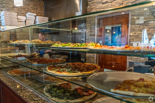 Grab a fresh slice of pizza at Taste of Tuscany in Peakness, NJ.
