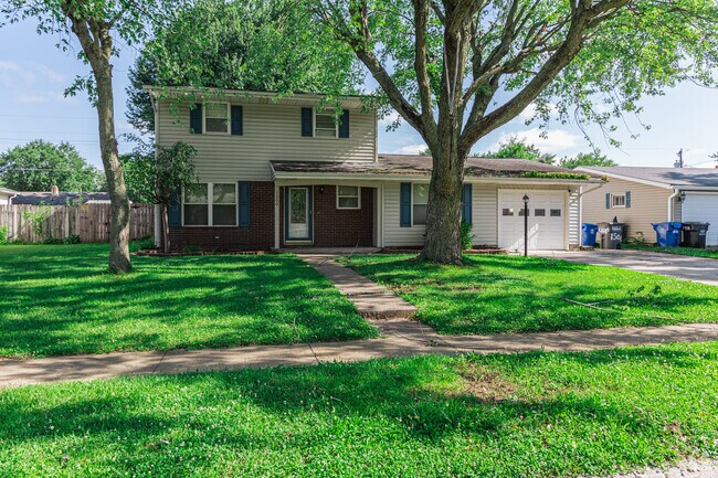 A bi-level home is shaded by mature trees, in Maple Crest.