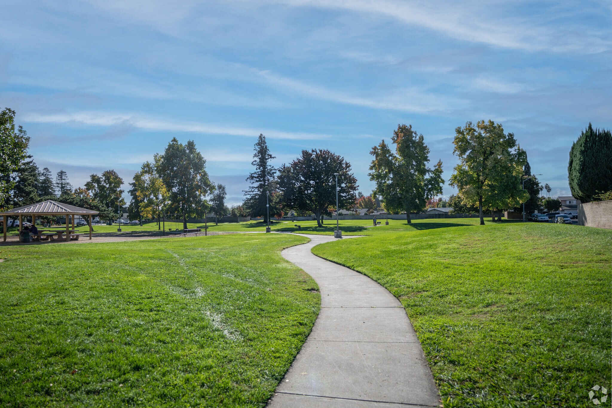 A covered picnic area with wide open green grass are features of this neighborhood park.