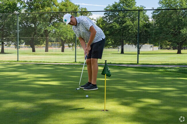 A Mulberry Hill college student practices his putt at the Fort Collins Nine Golf Course.