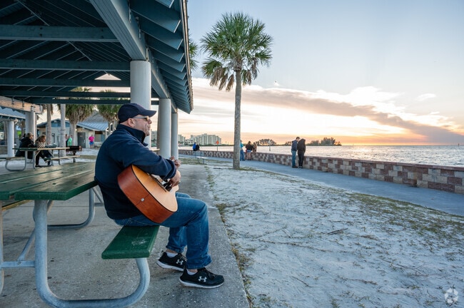 A guitarist sings a tune at Robert J. Strickland Memorial Park as the sun sets.