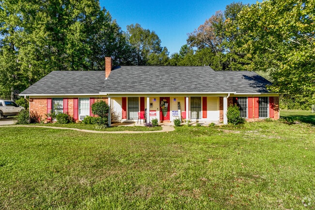 Seventies-era rambler with bright red shutters and picture windows.