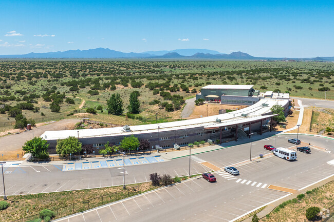 Academy for Technology & the Classics' large campus with the Sandia Mountains in the distance.