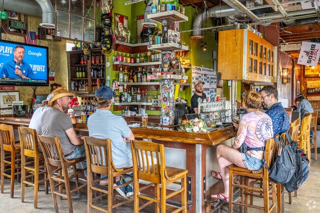 Patrons enjoy drinks and conversation at the inviting bar of Universal Joint, a favorite neighborhood hangout in Oakhurst.
