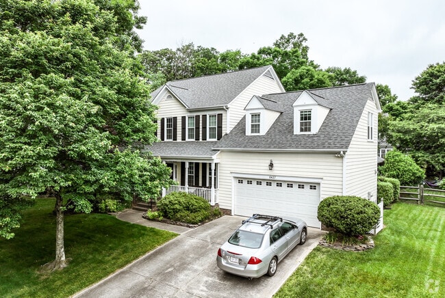 Mature trees block some of the view of this two-story traditional home in Highland Creek.
