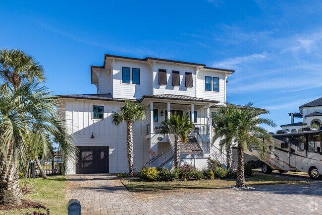 This stately beach house has some beautiful palm trees all around in Gulf Breeze.