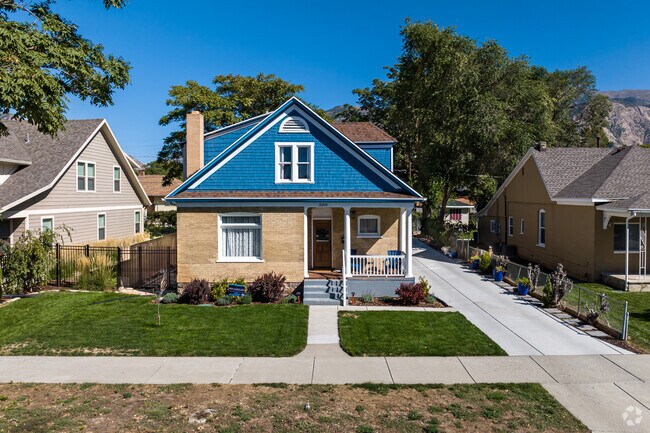 A historical home has blue details that stand out against beige brick.