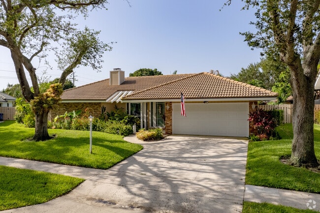 A gorgeous Spanish style home with immaculate landscaping located in Jupiter Town Hall.