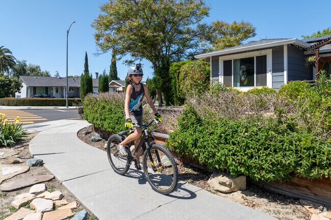 A young cyclist enjoys a sunny ride along a quiet sidewalk in Hidden Glen South.