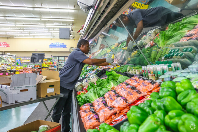 Warehouse Market employees keep the produce fresh at Warehouse Market near Carriage Trail.