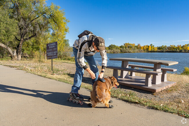 A Grove skater prepares his pooch for a ride along the Arkansas River Trail.