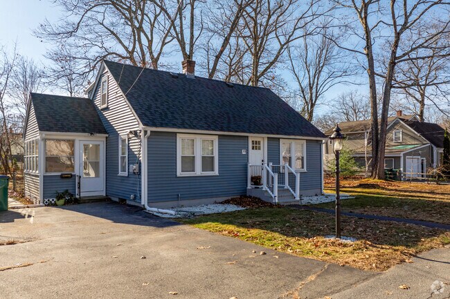 A blue cape style home in West Fitchburg has white accents and a driveway.