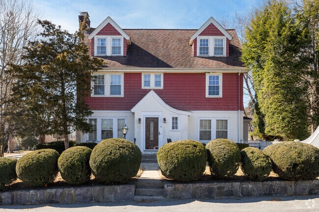 Lush bushes welcome you to this home in Wellesley Hills.