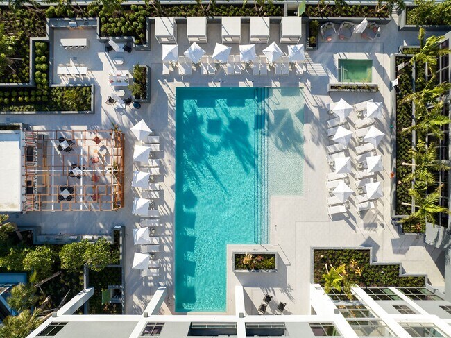 Indulge in the Miami sun on our expansive pool deck, offering luxury seating and a poolside bar