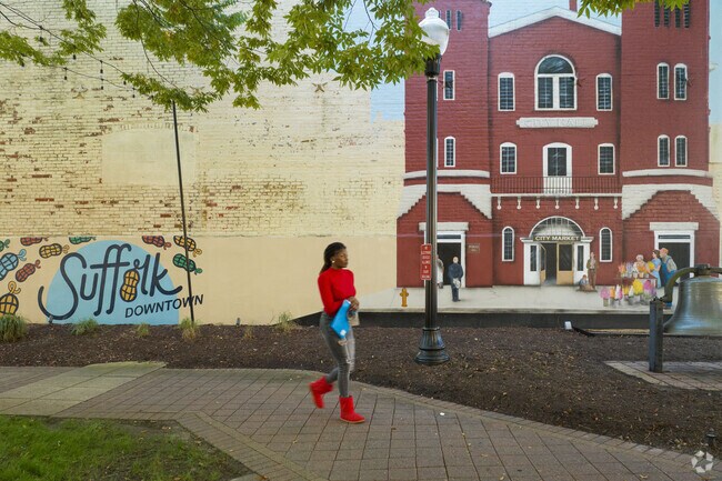 A pedestrian in Downtown Suffolk walks by a beautiful mural.