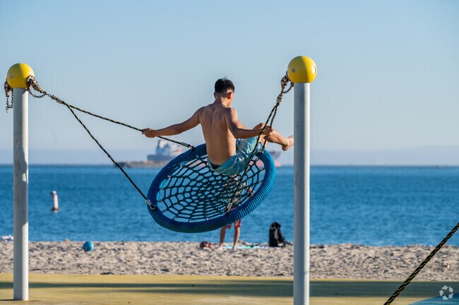 A resident swings towards the open ocean on the playground near Bluff Park.