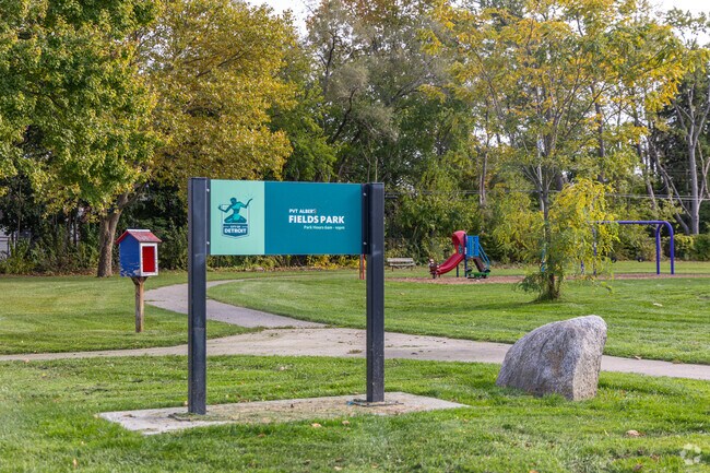 Fields Park includes a small playground, a little library box, and a large grass field.