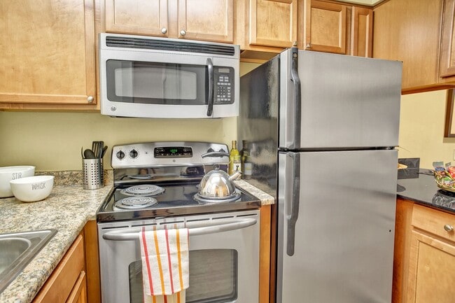 Colonial Square kitchen featuring stove, oven, microwave, sink,and refrigerator with lots of cabinet storage