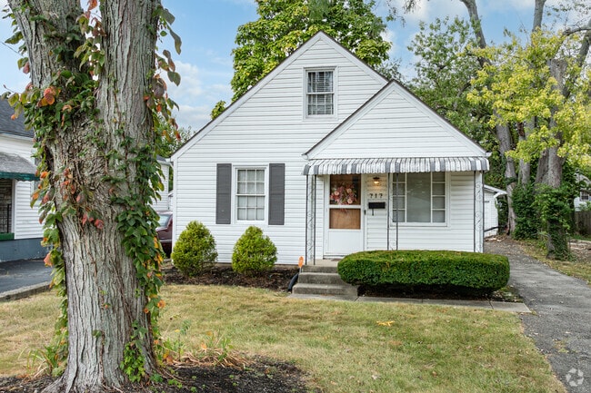 Streets in Residence Park have a mix of tall trees and bushy shrubbery, while lawns are grass.