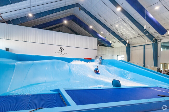 Scott's Pointe over in Calverton near Ridge has a new amusement park with a rideable sheet wave.