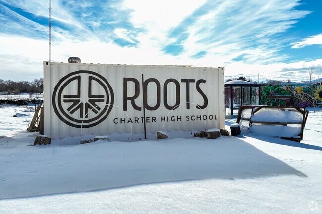 A metal structure serves as a sign at Roots Charter High School.