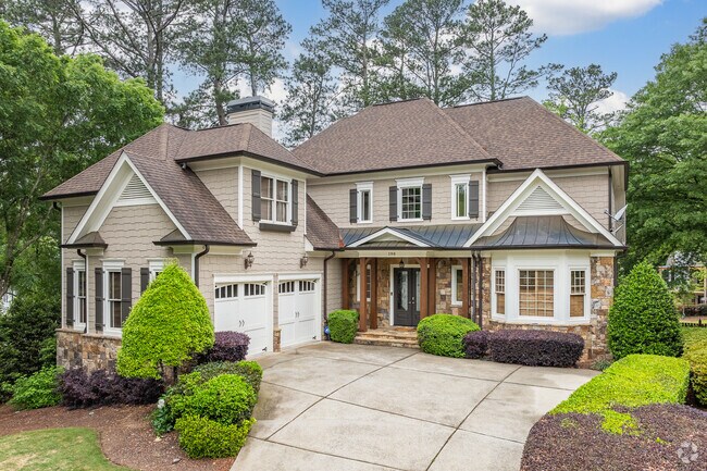 This elegant, two-story Craftsman-style home in Mountaire Springs features stone accents, a spacious driveway, and manicured landscaping.