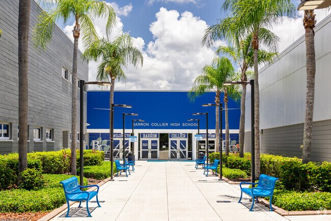 The front entrance at Barron Collier High School in Naples has seating under palm trees.