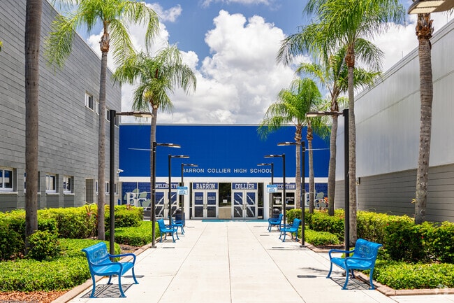 The front entrance at Barron Collier High School in Naples has seating under palm trees.