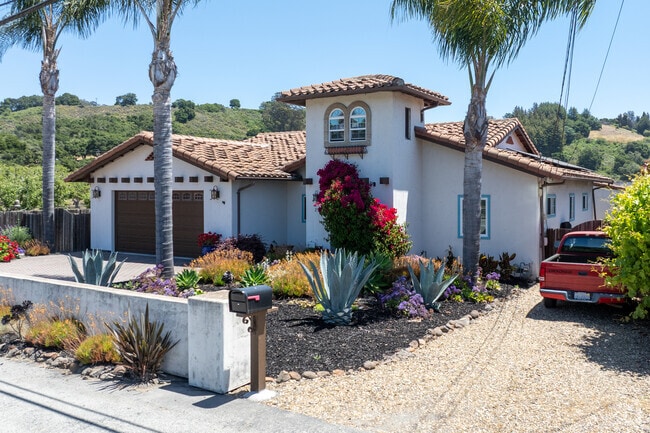 Mediterranean Revival home in Corralitos with lush landscaping and vibrant curb appeal.