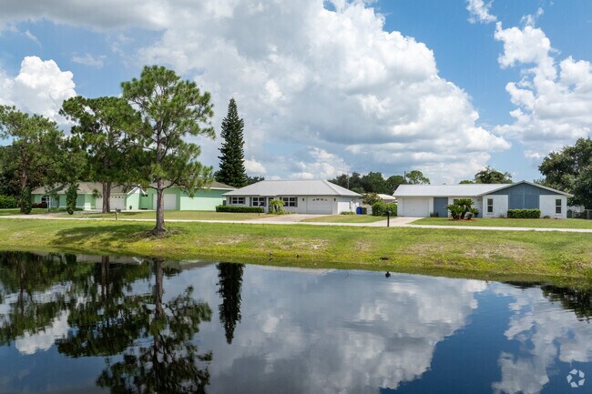 A row of homes reflect in the pond in the center of West Sebring.