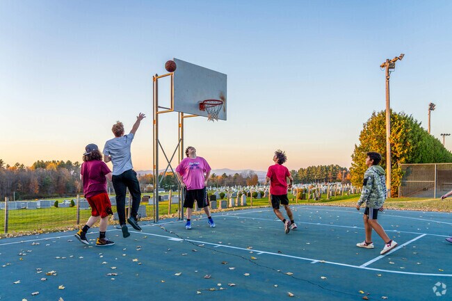 Kids play a game of pickup basketball at a court with scenic views of the Green Mountains.