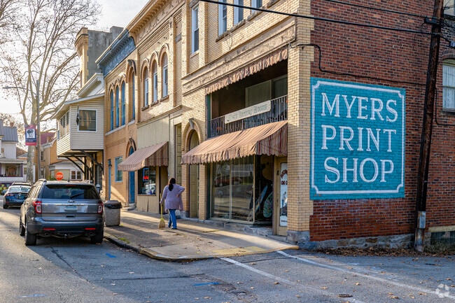 A Vandergrift resident sweeps the sidewalk in front of Myers Print Shop.