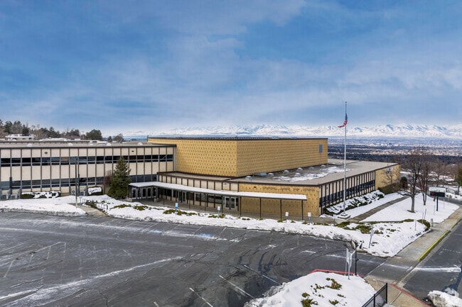 The front of Churchill Junior High School in Mount Olympus, with snowy mountains behind.